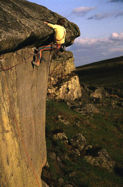 Al about to roll over onto the topout of this crag classic